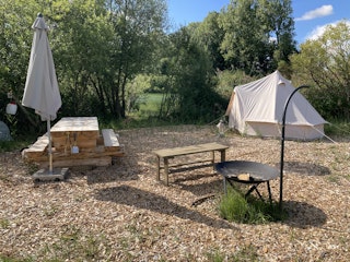 Dein Lager umgeben von Schilf und Feldern. Du musst dein eigenes Zelt mitnehmen. Das Zelt auf dem Foto gehört einem Camper.