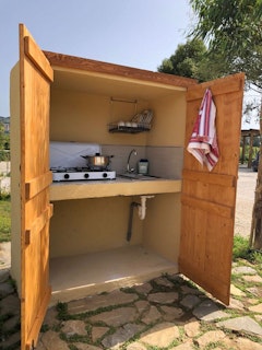 Kitchenette on pitch and outdoor shower behind the kitchen facility