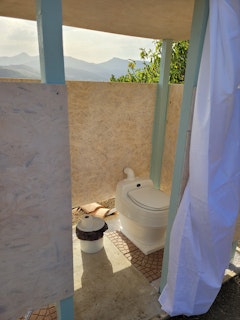 Les toilettes à compost à côté sont l'une des deux douches solaires.
